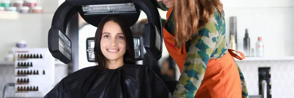 Mulher feliz bonita senta-se na cadeira e seca o cabelo — Fotografia de Stock