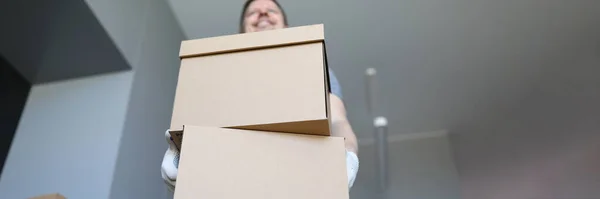 Ein Lader in einem leeren Raum hält einen Karton — Stockfoto