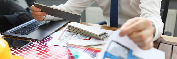 Человек сидит за столом с устройствами и цветовой гаммой