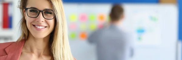 Blonde female employee smiling in the office