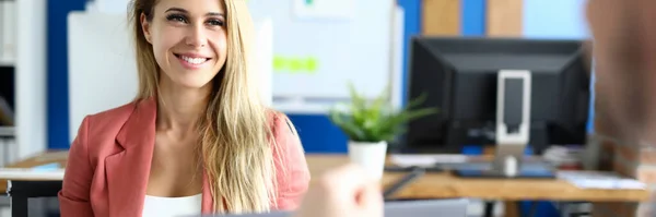 Beautiful employee sits in front of her boss