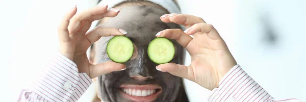 Смеющаяся женщина в косметической маске на лице — стоковое фото