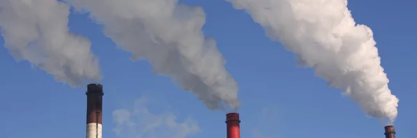 Close up della pipa di impianto con fumo contro il cielo blu — Foto Stock