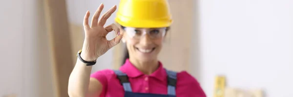 Mulher construtor sorrindo e mostrando gesto OK na oficina — Fotografia de Stock