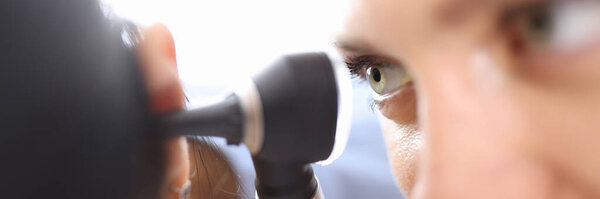 Врачи, держащие отоскоп вблизи уха пациентов в клинике крупным планом