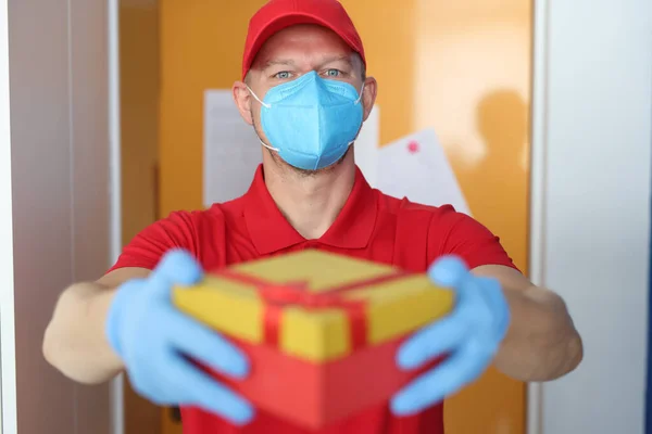 Mensajero con máscara de protección médica traído caja con guantes de protección — Foto de Stock