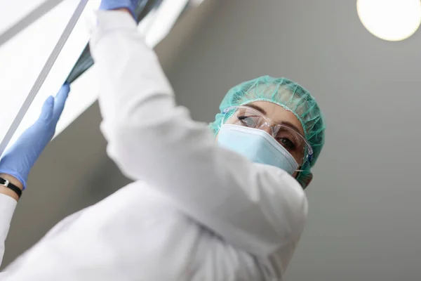 Medik drží rentgen v ochranné masce. — Stock fotografie