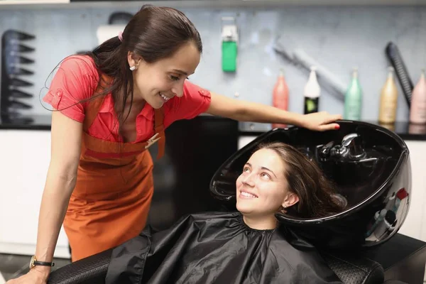 Friseur erklärt Kundin, wie sie ihre Haare richtig wäscht — Stockfoto