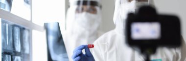 Koruyucu giysili iki doktor analiz için röntgen çeker ve kameraya çeker..