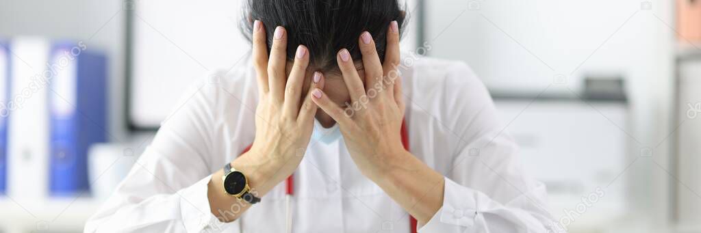 Tired doctor bowing his head in office after working day