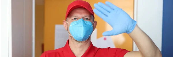 Courier in protective medical mask and gloves holds gift box in his hands. — Stock Photo, Image