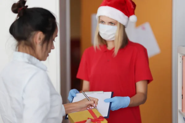 Mensajería de mujer en máscara médica protectora y guantes entrega paquete — Foto de Stock