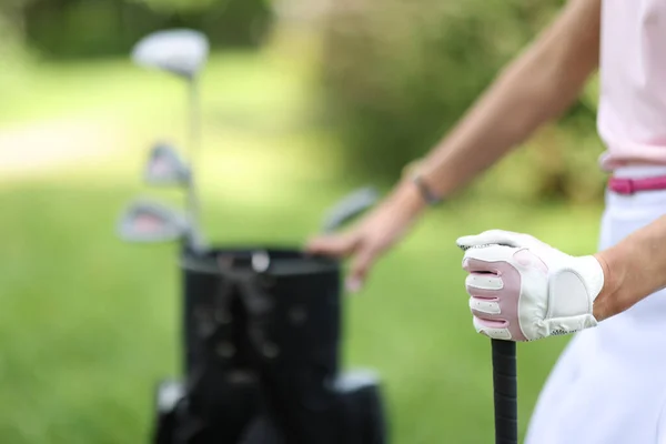 Female hand of golfer in glove holds bag with golf clubs — Stock Photo, Image