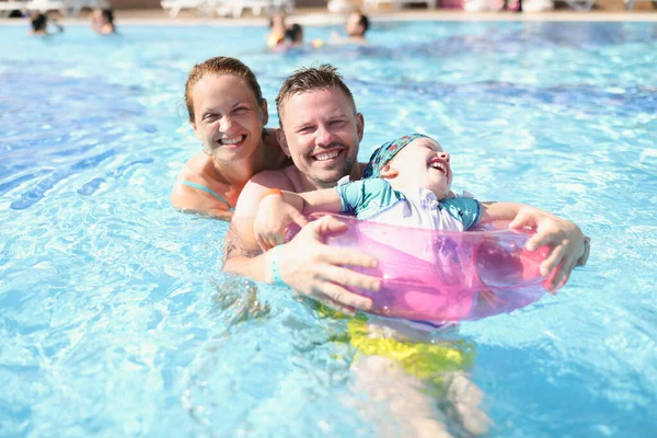 Család anya apa és lánya nevetnek és úsznak a medencében — Stock Fotó