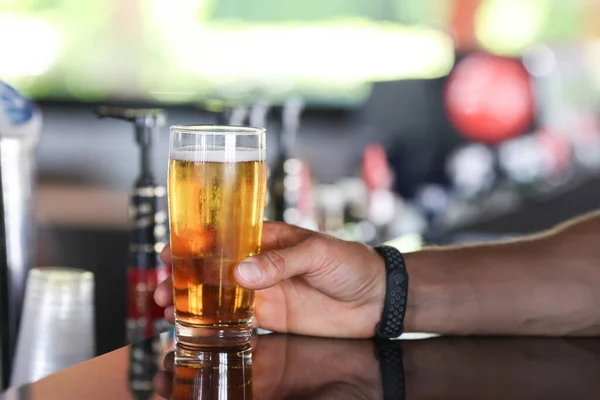 Mans kézben tartja üveg sör a bárban — Stock Fotó