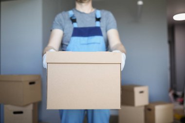 Erkek kurye büyük bir karton kutu tutuyor.