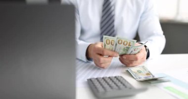 Takım elbiseli adam $4K film sayıyor.