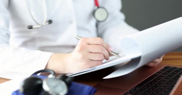 Doctor llena documentos médicos en su escritorio 4k película — Vídeos de Stock