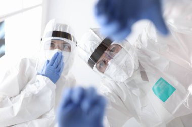 Koruyucu antiveba elbiseli doktorlar hastaya yardım ediyor.