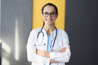 Beyaz önlüklü gülümseyen doktorun portresi.