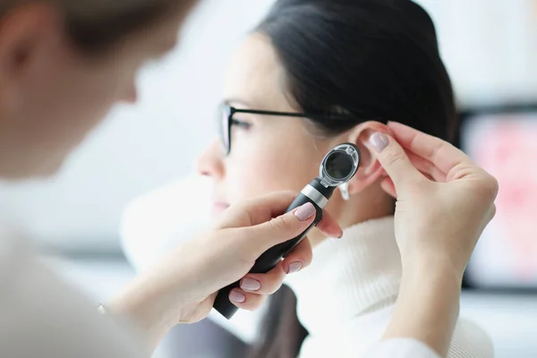 Оториноларинголог изучает ухо пациента с помощью отоскопа — стоковое фото
