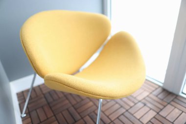 Sarı, modern, şık koltuk kapalı mekanda duruyor.