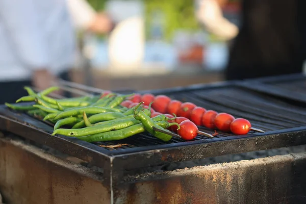 Kucharz przygotowuje zieloną paprykę i grillowane pomidory — Zdjęcie stockowe