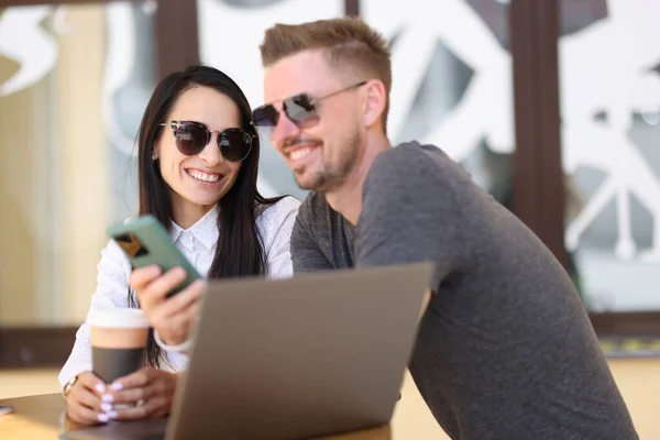 Le man och kvinna i solglasögon kommunicera i kaffe nära laptop — Stockfoto