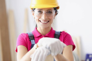 Sarı şapkalı gülümseyen kadın müteahhit portresi.