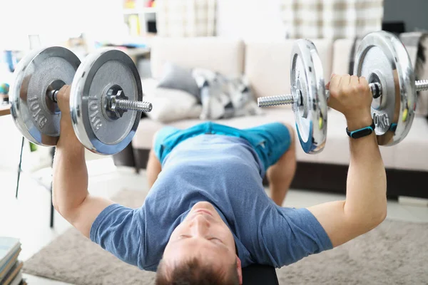 Jeune homme faisant des exercices avec haltères lourdes pour les muscles des biceps — Photo