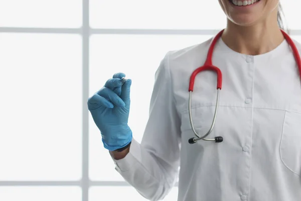 Mulher médico de casaco branco segura caneta na mão — Fotografia de Stock