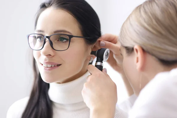 Doctor conducts examinations of ear area for woman — Stock Photo, Image