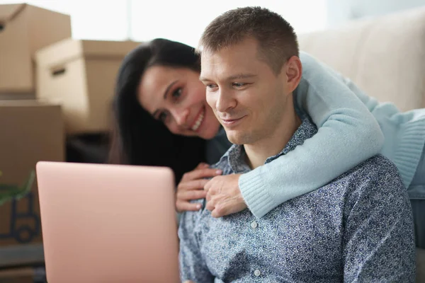 Kvinna kramar man mot bakgrund av lådor i en lägenhet — Stockfoto