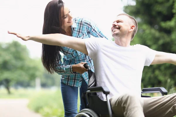 Glad man i rullstol för promenad med kvinna — Stockfoto