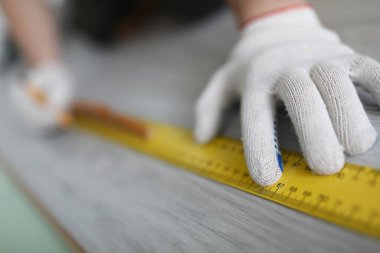 Efendimizin elleri, cetvelle lamine üzerinde ölçümler yapıyor.