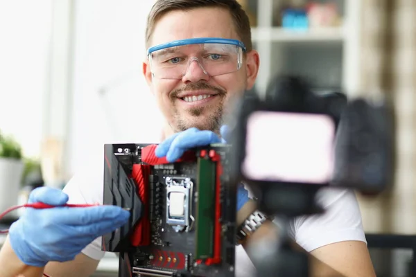Блогер демонстрирует на камеру ремонт компьютерной платы — стоковое фото