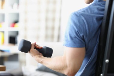 Erkek el, evde siyah dambıl kaldırıyor.