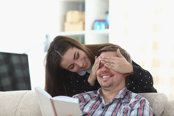 Människan läser boken hemma. Kvinnan blundar — Stockfoto