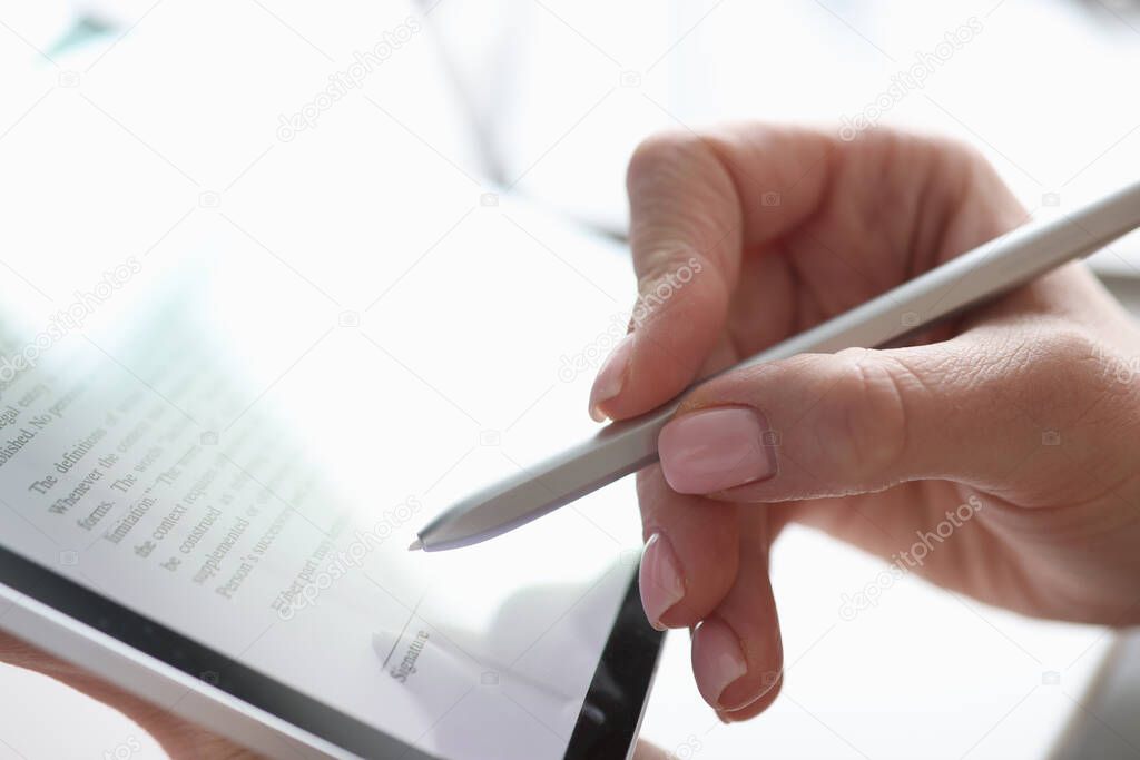 Female hand puts electronic signature in tablet with stylus