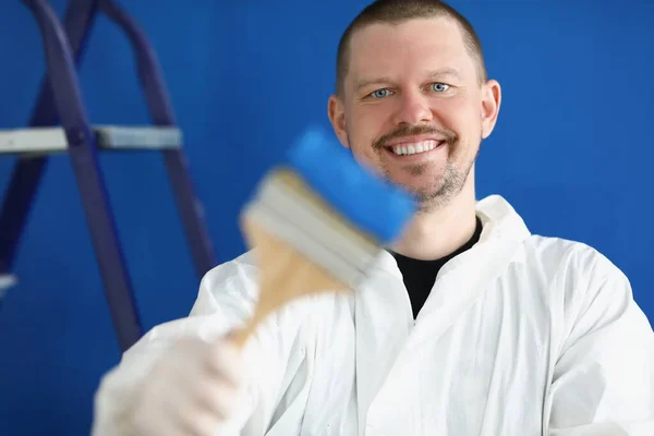 Retrato de jovem trabalhador da construção masculina em terno protetor com pincel e pintura — Fotografia de Stock