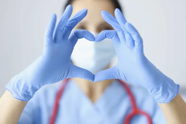 Médecin en gants de caoutchouc montrant le coeur avec les mains gros plan — Photo