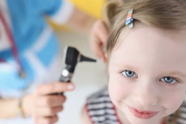 Médico examinando orelha com otoscópio para pequena menina sorridente — Fotografia de Stock