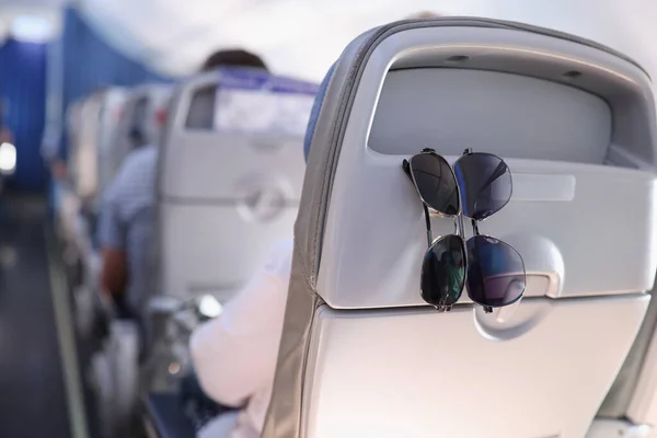 Uçakta yolcu koltuğunda asılı duran iki güneş gözlüğü. — Stok fotoğraf