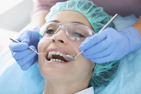 Zubař vyšetřující dutinu ústní pacientky — Stock fotografie