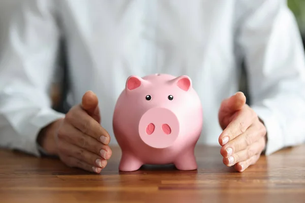 There is pink piggy bank inside human hands — Stock Photo, Image