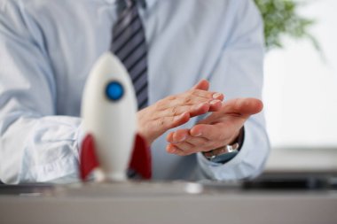 Ofiste alkışlayan bir adam ve yakın planda roket.