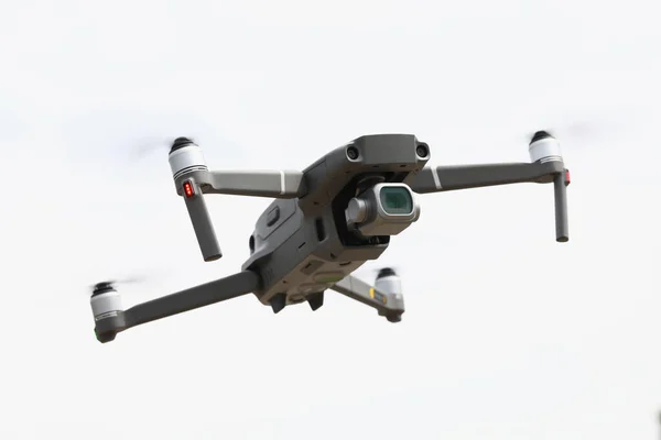 Un drone argentato vola in cielo. Drone fotografia aerea — Foto Stock