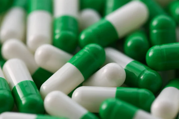 Large number of pharmaceutical white-green tablets closeup — Stock Photo, Image