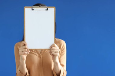 Elleri gözünün önünde boş bir belgeyi elinde tutan bir kadın.