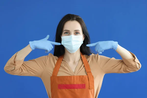 Vrouw ober in rubber handschoenen tonen beschermende masker op haar gezicht — Stockfoto